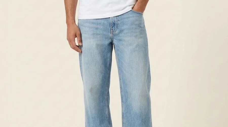 Model in light-wash relaxed jeans with a roomy straight leg, standing in daylight