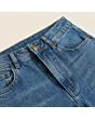 Close-up of the waistband, button and fly on women's mom jeans