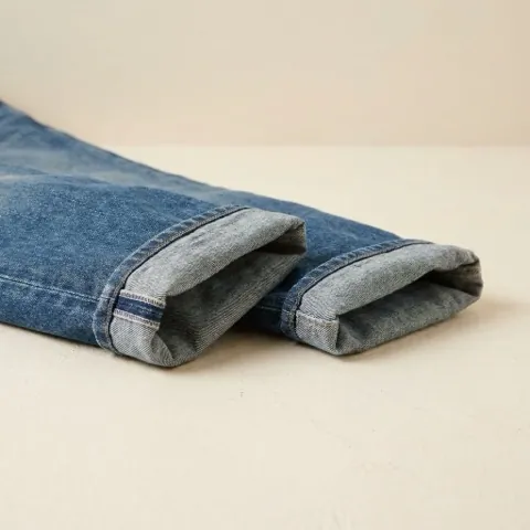 Close-up render of a jeans hem with a single turned-up cuff