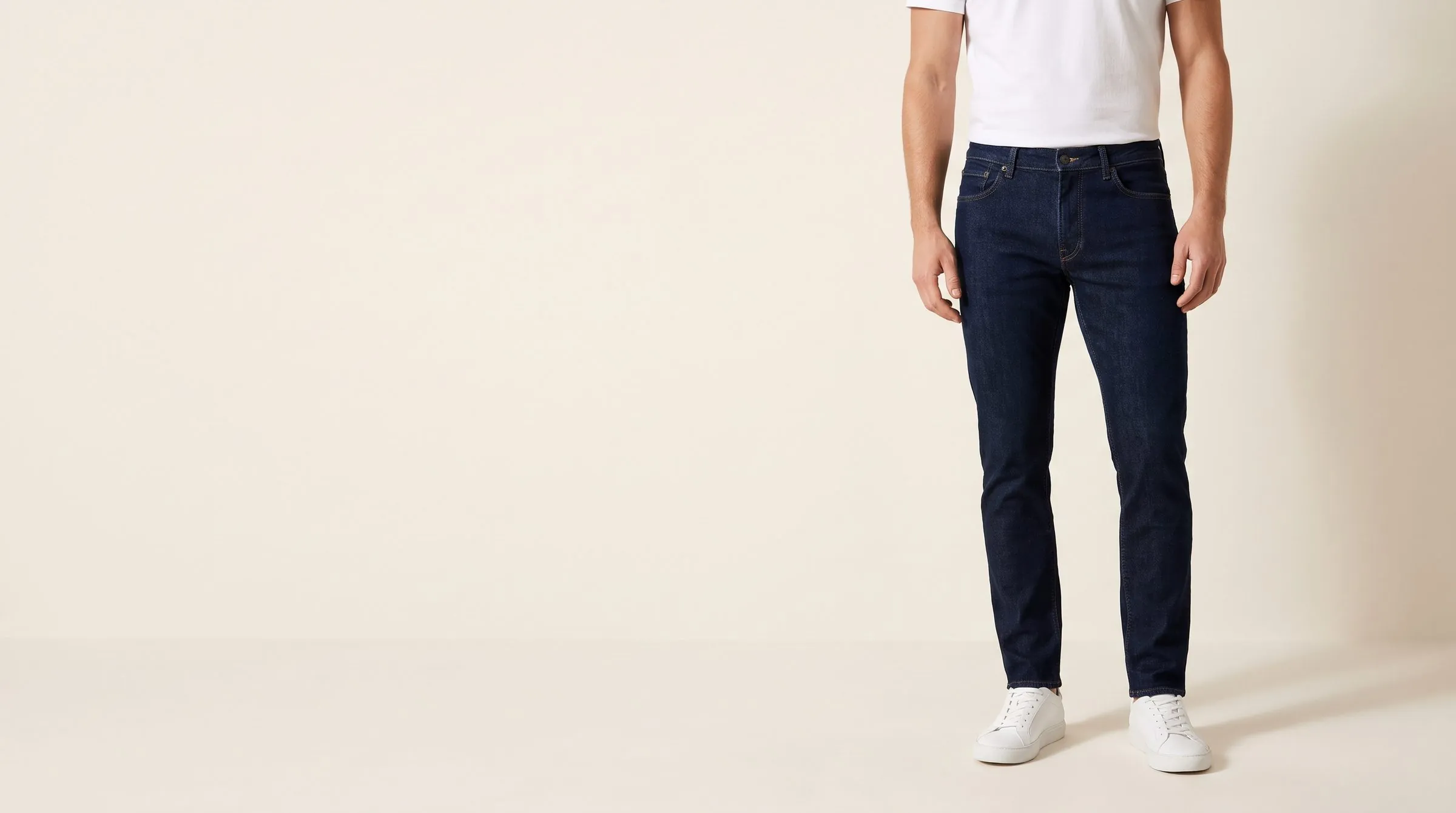 Men's skinny, slim and straight jeans in three washes stacked on a cutting table with fabric swatches