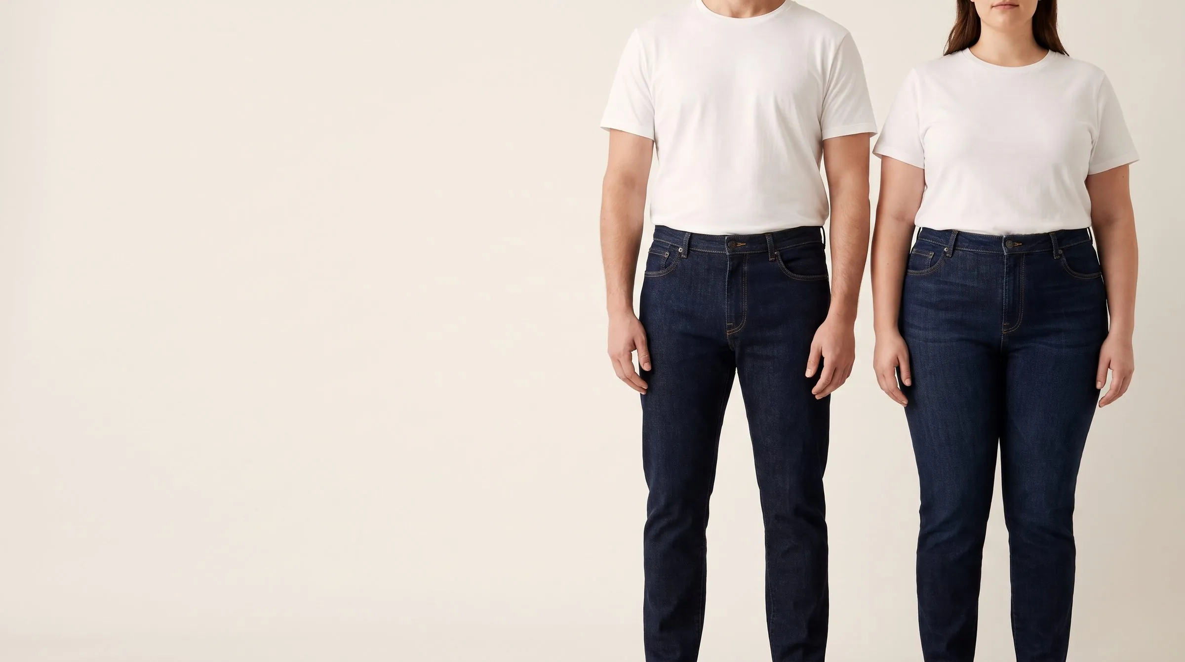 Relaxed mid-wash jeans with a high waistband folded on a cutting table, a tape measure across the waistband