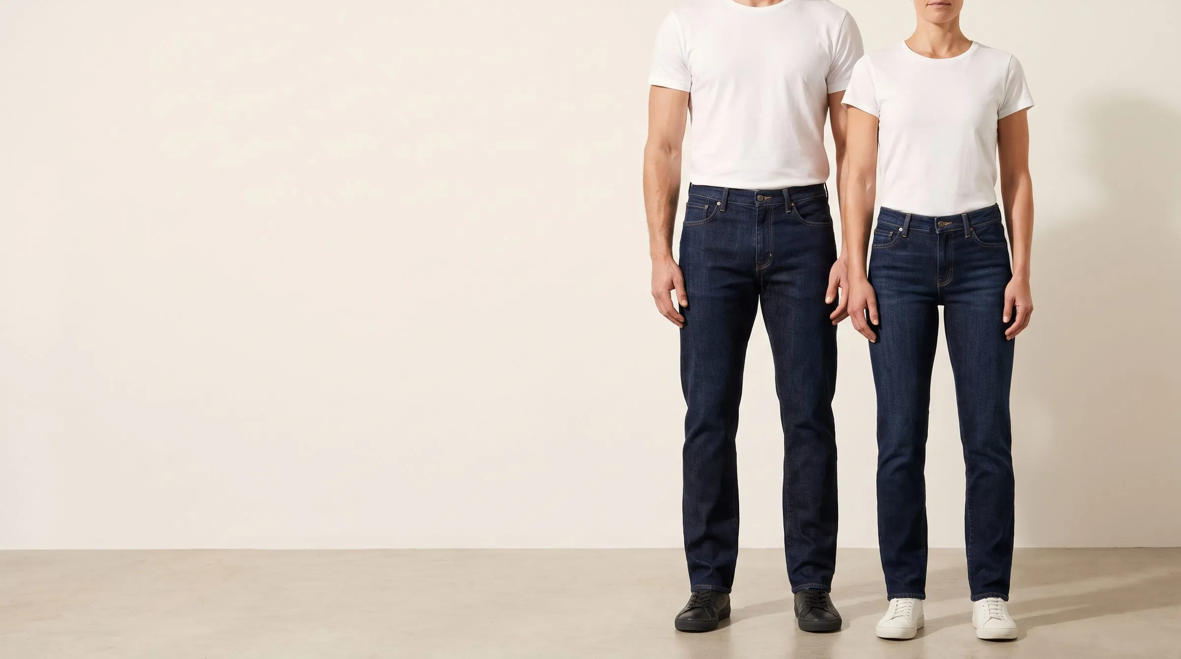 Dark stretch jeans with a full thigh tapering to the ankle on a cutting table, a tape around the thigh