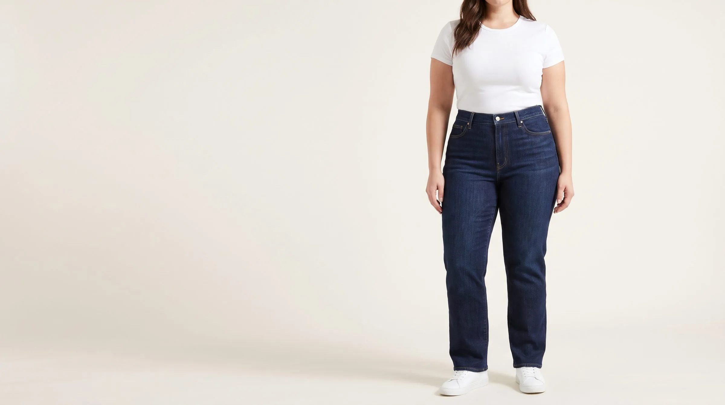 Straight, bootcut and wide leg jeans folded on a table, four waistbands stacked to show low to ultra-high rise