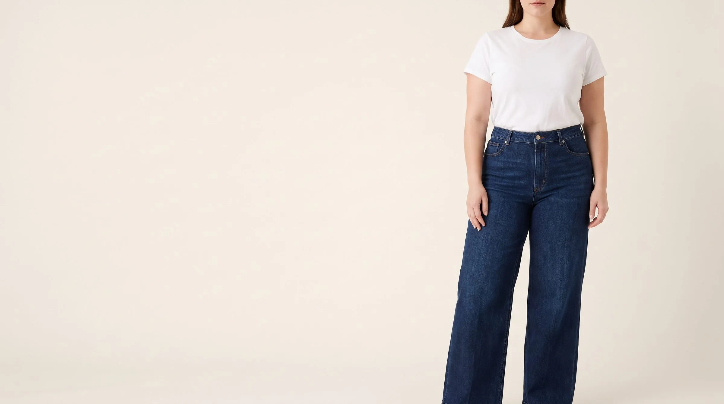 Wide leg, flare and barrel jeans spread out on a table, the hems fanned wide, chalk lines at the narrow hip