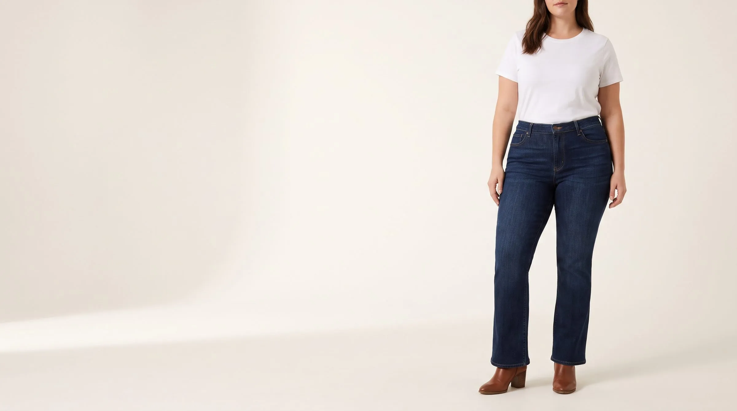 A paper jeans pattern with the high-hip curve chalked just below the waist, bootcut jeans folded beside it