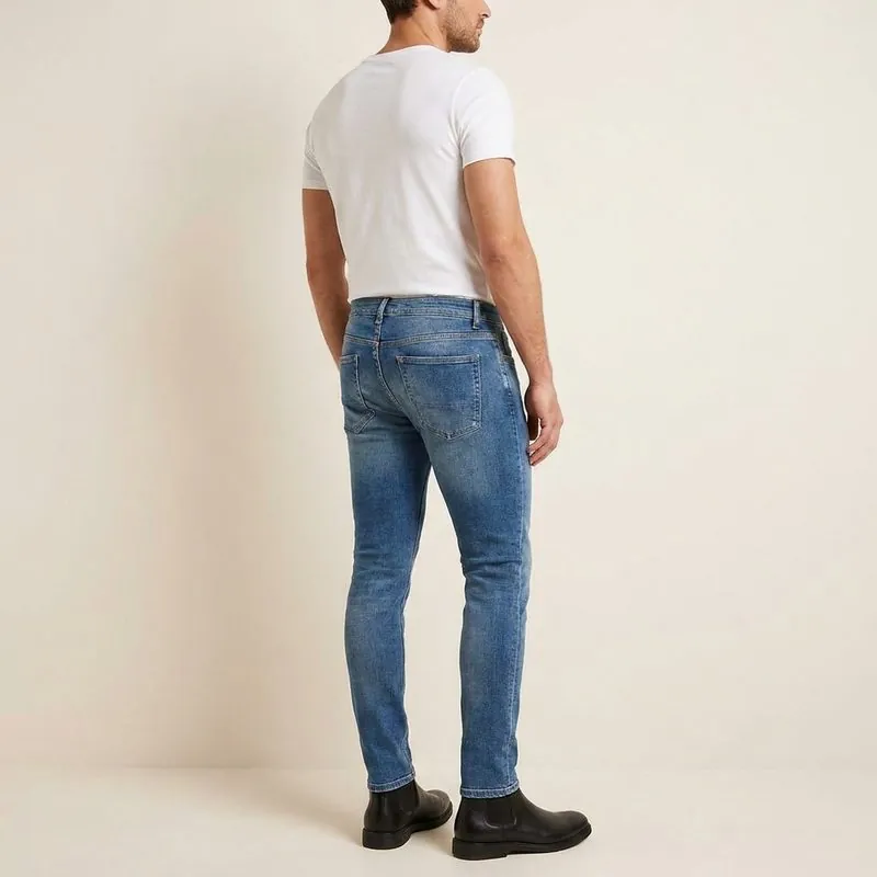 Skinny jeans worn by a man with a trapezoid body shape, back view