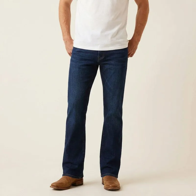 Man in dark-wash bootcut jeans with leather boots