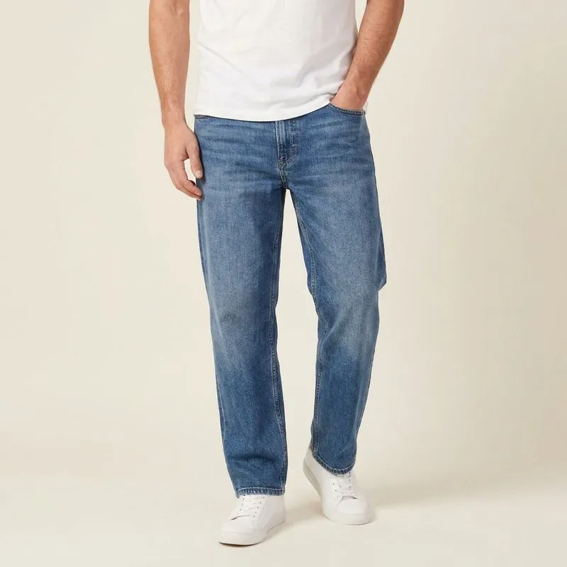 Relaxed jeans in mid wash, worn on a model