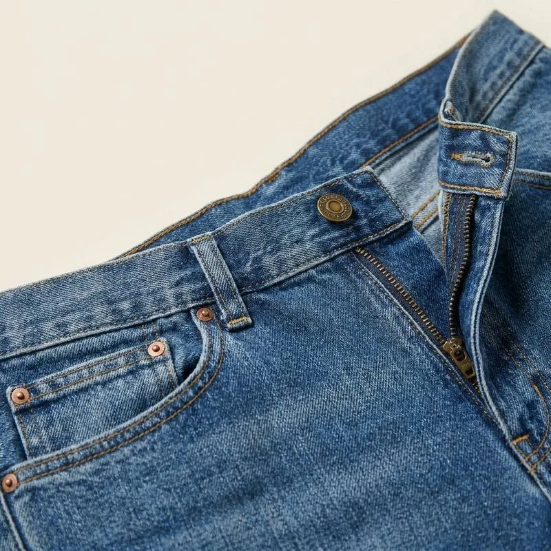 Close-up of the waistband, button and fly area of straight jeans