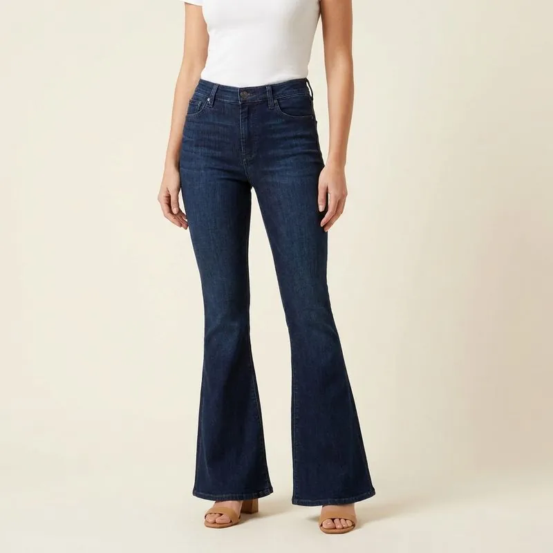 Model wearing dark flared jeans hemmed to the shoes