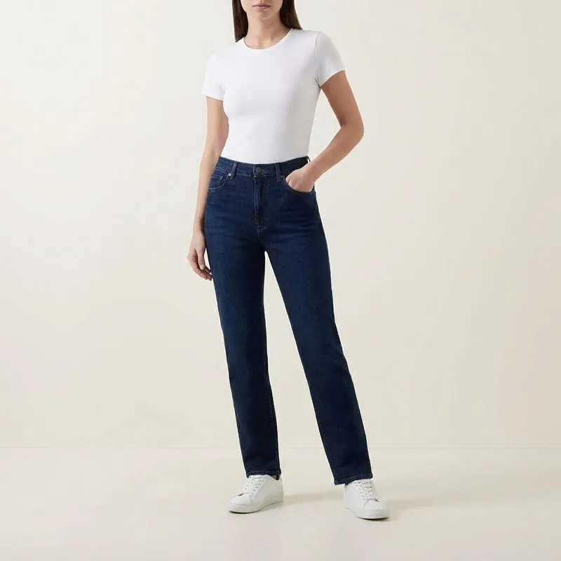 Woman in dark-wash straight jeans with a blazer and loafers